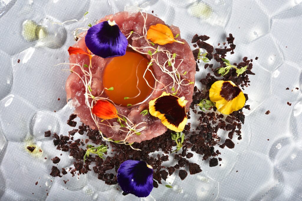 Tartare di ricciola con gelè agrumato e terra di olive taggiasche